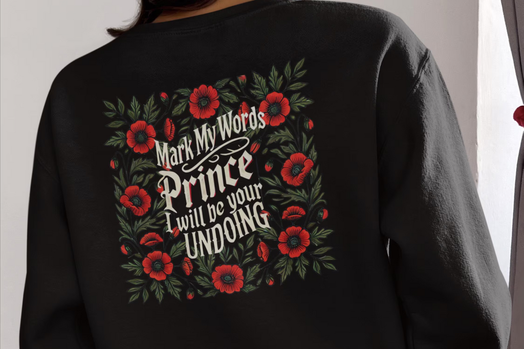 Black sweatshirt with floral design and text on the back, worn by a person.